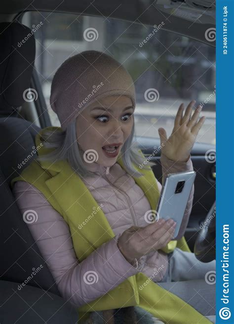 shocked middle aged asian blond woman in the car asian woman use mobile phone sitting and