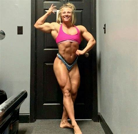 A Female Bodybuilt Posing For The Camera With Her Arms And Legs Up