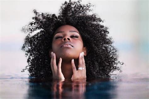 A Woman Is Floating In The Water With Her Hands On Her Face And Eyes Closed