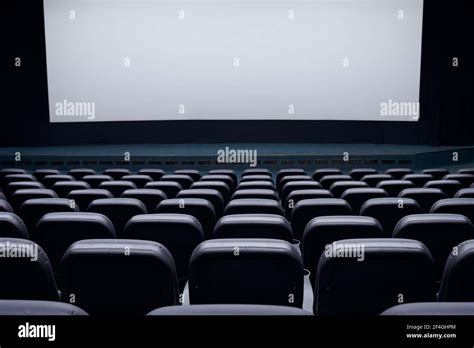 Cinema Auditorium With Black Seats And White Blank Screen Concept Of