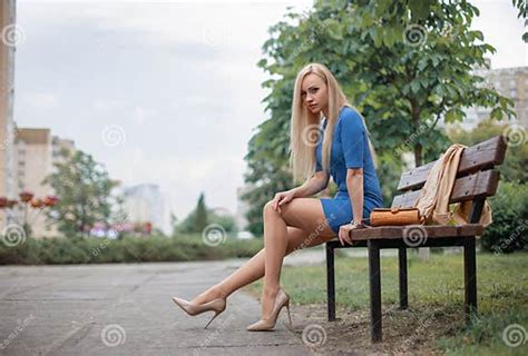 Girl With Perfect Legs In Pantyhose Sitting On The Bench In The Park