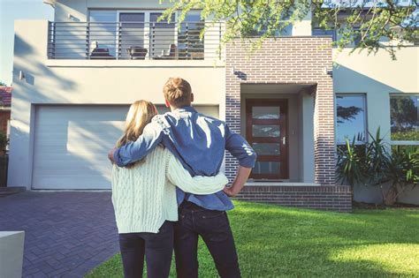 Couple Standing In Front Of Their New Home Lanser