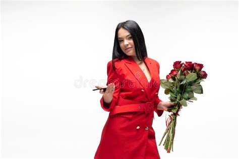 Beautiful Brunette In Red Jacket Holding A Bouquet Of Red Roses Stock