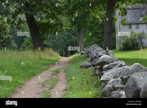 A Dirt Road And Stone Wall At The Concord National Historic Site Near