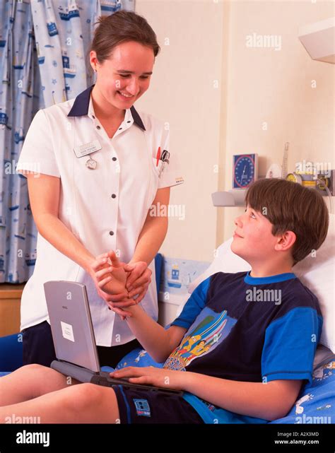 Hospital Paediatrician Nurse With Young Boy Patient Checking Pulse