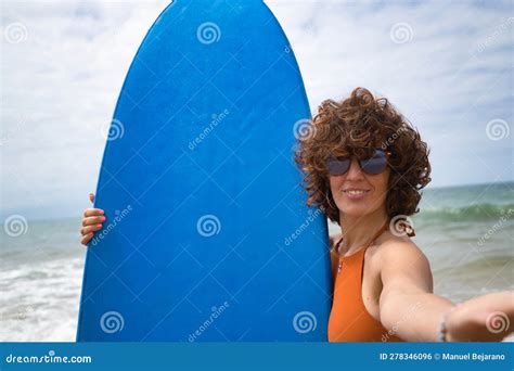 Attractive Mature Woman With Curly Hair Sunglasses And Bikini Taking A Selfie While Holding A