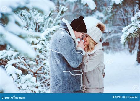 Winter Portrait Of Happy Romantic Couple Warm Up Each Other On The Walk In Snowy Forest Stock
