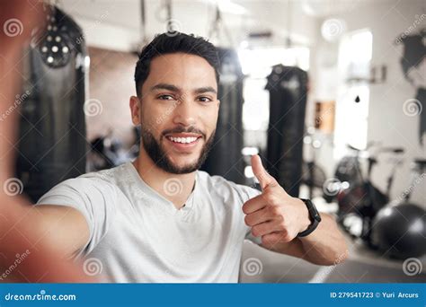 man portrait and selfie at a gym for fitness with thumbs up for wellness or health in a close