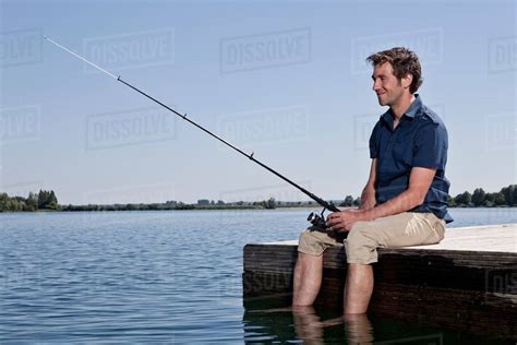 Man Fishing On Dock Stock Photo Dissolve