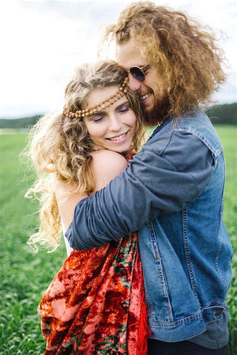 Young Beautiful Hippie Couple Walking In Green Summer Field Stock Image