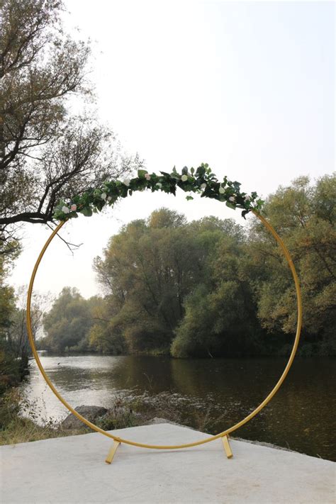 A Golden Circle With Greenery On It Near A River