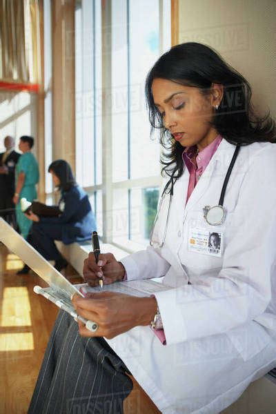 Female Indian Doctor Marking On A Chart Stock Photo Dissolve