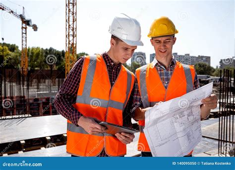 Structural Engineer And Construction Manager Dressed In Orange Work