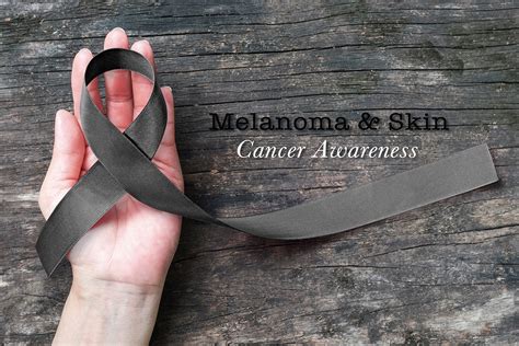 Melanoma And Skin Cancer Black Awareness Ribbon On Human Helping