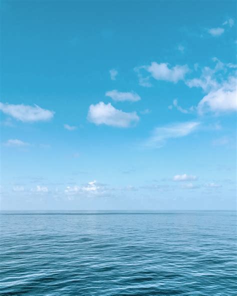 Blue Body Of Water Under Blue And White Sky During Daytime Photo Free