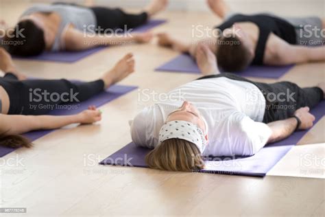 Group Of Young Sporty People In Savasana Pose Stock Photo Download