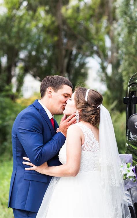 Groom Kissing Bride Outdoors Stock Image Image Of Bouquet Female