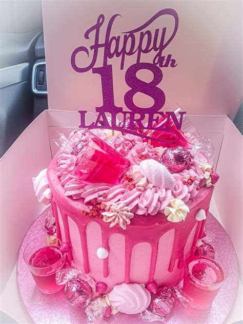 A Pink Birthday Cake Sitting On Top Of A Table