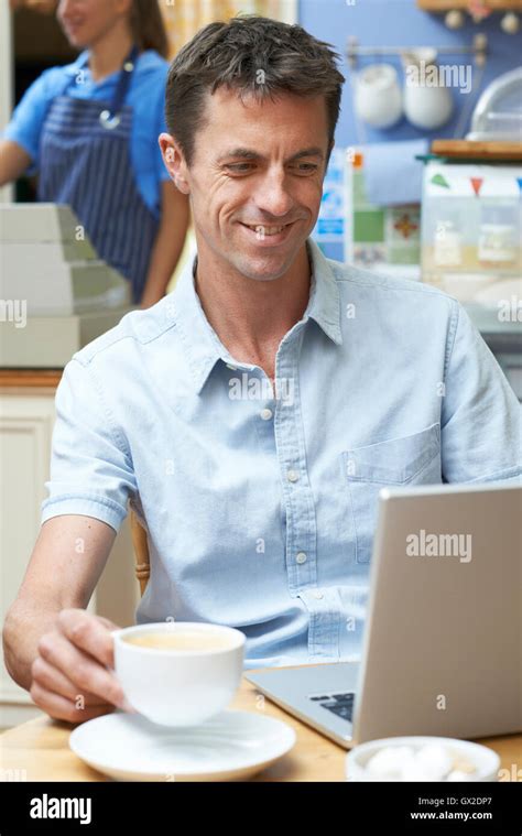 Man In Coffee Shop Using Laptop Computer Stock Photo Alamy