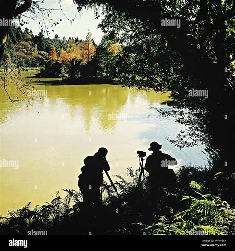 Silhouette Men Photographing By Lake Stock Photo Alamy