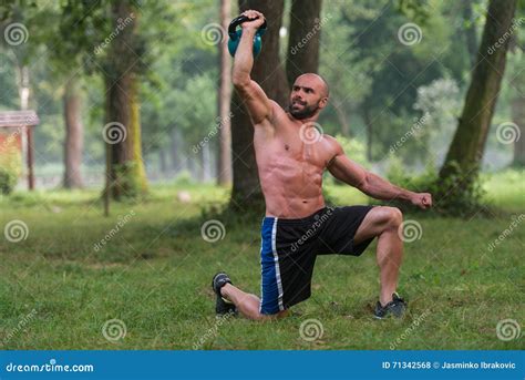 Kneeling Muscular Man Exercising With Kettlebells Stock Photo Image