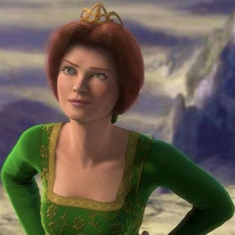 A Woman With Red Hair Wearing A Green Dress And Gold Tiara Standing In