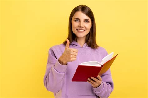 Satisfied Woman Showing Thumbs Up Gesture Holding And Reading Book