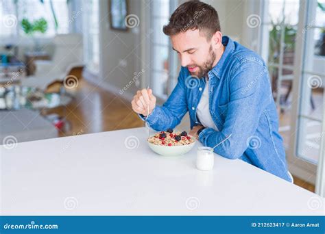 Handsome Man Having Breakfast Eating Cereals At Home And Smiling Stock Image Image Of Bright