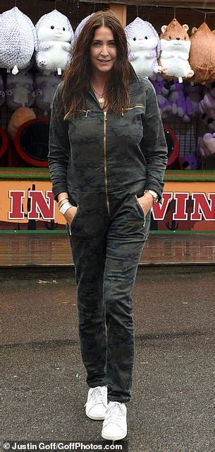 Lisa Snowdon Braves The Rain As She Dons A Blue Poncho At A Theme Park