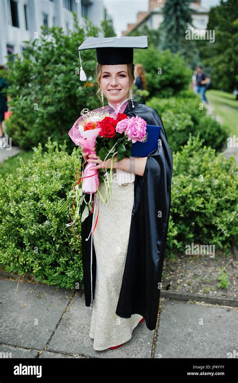 Portrait Of A Beautiful Female Graduate In Dress And Graduation Gown