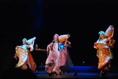 Three Women In Colorful Dresses Are Dancing On Stage