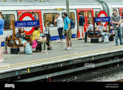 Passengers Sit On Benches At Earls Court London Underground Station
