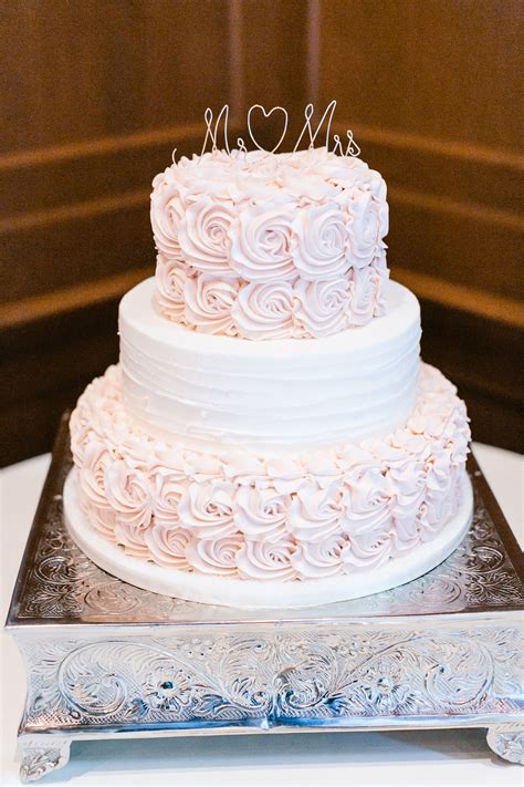 Three Tier Wedding Cake With Frosted Pale Pink Roses On The Bottom