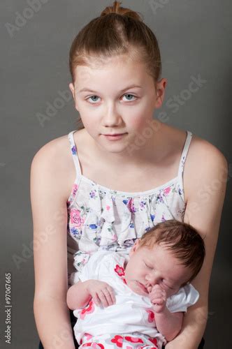 Young Girl Holding A Baby Stock Photo Adobe Stock
