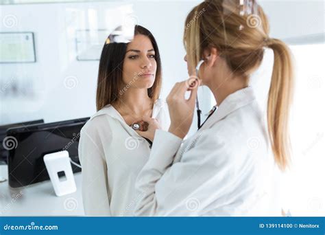 Confident Woman Being Examined With Stethoscope By Doctor In The