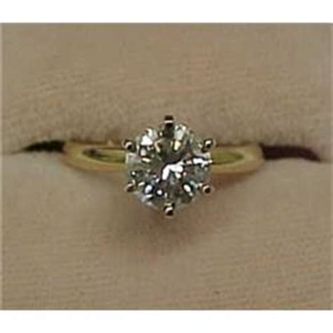 The weight of a gemstone. One and a half carat diamond solitaire ring, 14K yellow ...