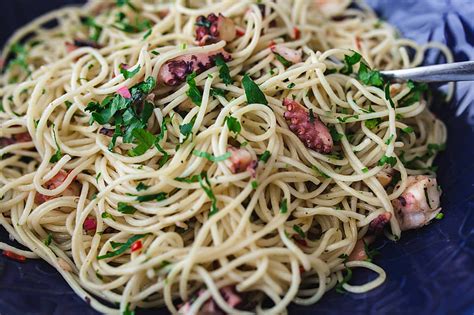 This traditional italian christmas dinner includes at least seven different types of seafood. Royalty-Free photo: Fancy dinner with seafood pasta, crayfish and red wine by the table ...