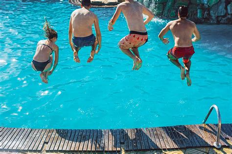 Friends Jumping In The Swimming Pool By Stocksy Contributor Lumina