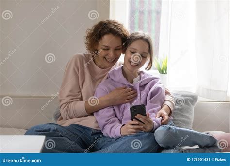 Feliz Hija Adolescente Y Madre Joven Usando Un Smartphone En Casa