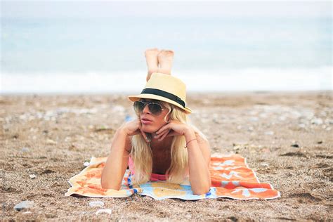 Woman In Sunglasses Sunbathing On Beach By Jovana Rikalo Stocksy United