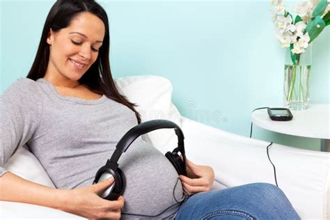 Mujer Embarazada Que Juega Música A Su Bebé Foto De Archivo Imagen De