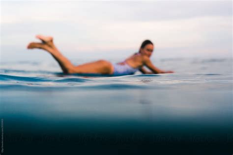 Woman Lying On Surfboard In The Ocean At Sunset Del Colaborador De