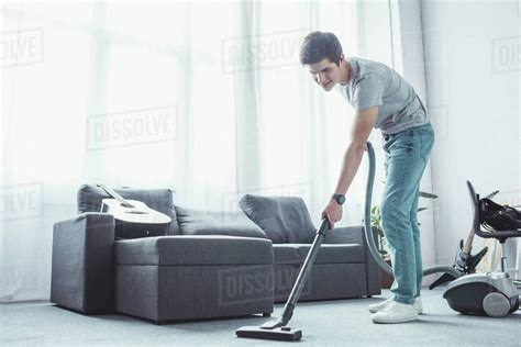 Teenager Vacuuming Floor In Living Room With Vacuum Cleaner Stock