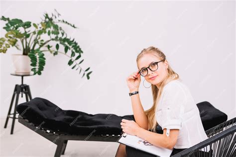 premium photo smiling portrait of a beautiful psychologist sitting on chair with clipboard in