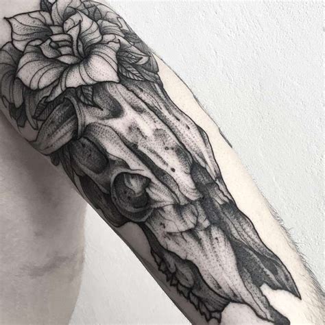 Awesome vintage style black ink animal skull tattoo on arm combined