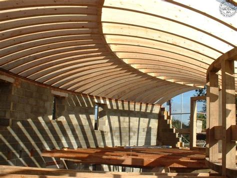 A decked terrace sheltered beneath the curving roof connects this space with an office and kitchen on the opposite side, which are separated from the lounge area by a small alley. Curved glulam roof | Round & Octagon Barns or House ...