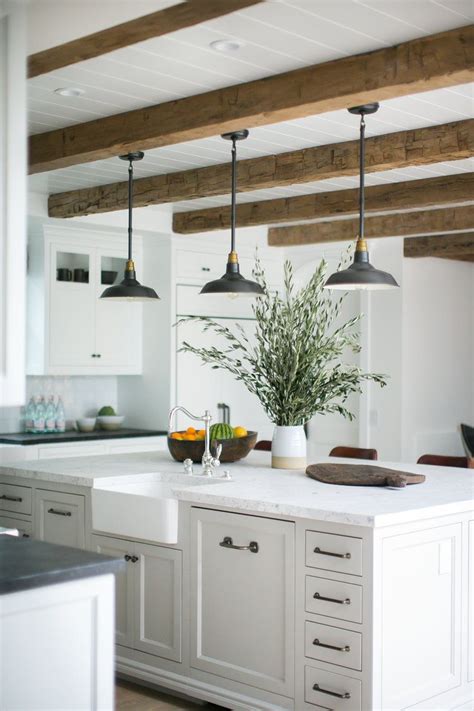 A large kitchen island without a sink or cooktop built in provides tons of extra counter space, making it easy to do all of the above and more. Rustic beams and pendant lights over a large kitchen ...