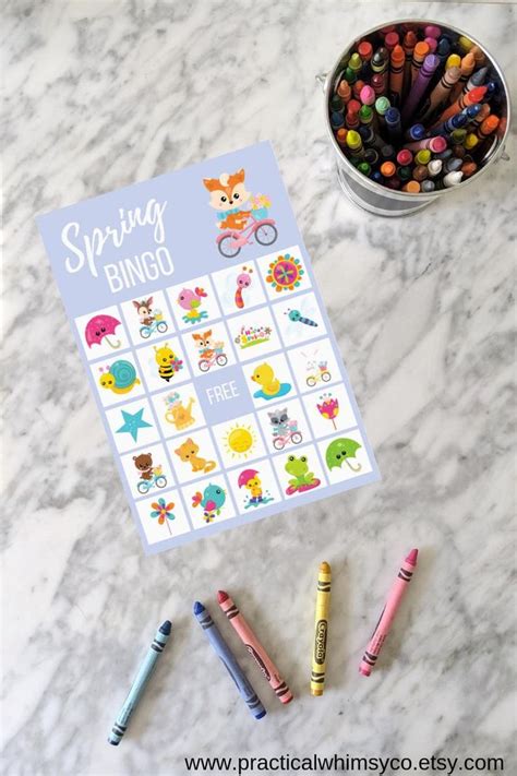 The Spring Bingo Game With Crayons Markers And Pencils Next To It