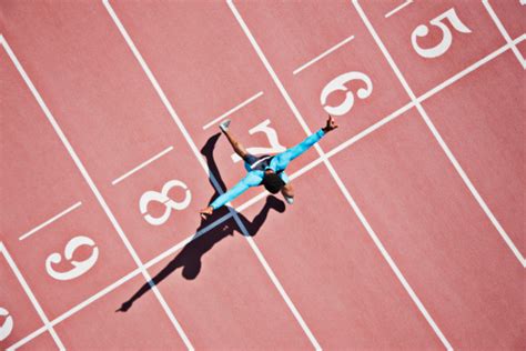 Runner Crossing Finishing Line On Track Stock Photo Download Image