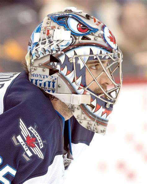 A Hockey Goalie Wearing A Mask And Looking Away From The Camera In